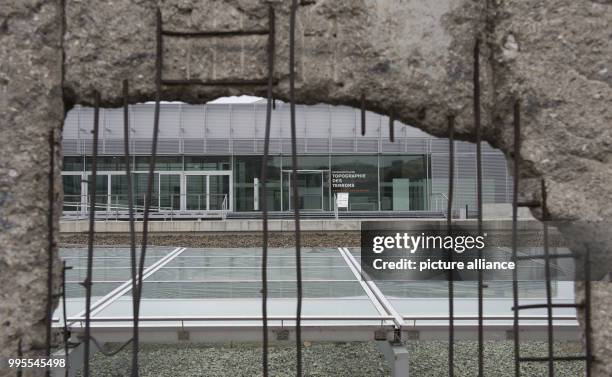 The visitor center on the grounds of the memorial site Topographie des Terrors can be seen through a hole in the former border wall in Berlin,...
