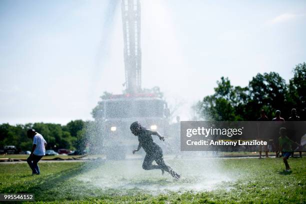 Children play under a firehose at Mud Day at Nankin Mills Park on July 10, 2018 in Westland, Michigan. The event has taken place for the past 31...