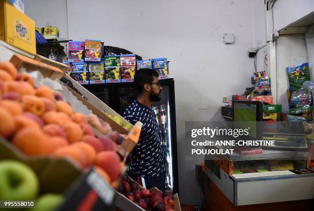 General store vendor looks at a television in a shop in Marseille on July 10 as he watches the action during the 2018 Russia World Cup football match...
