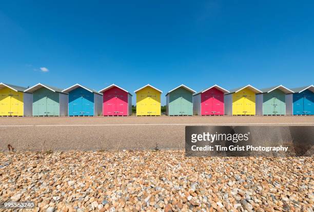 a row of multi-coloured beach huts along the promenade, eastbourne, east sussex - british culture stock pictures, royalty-free photos & images