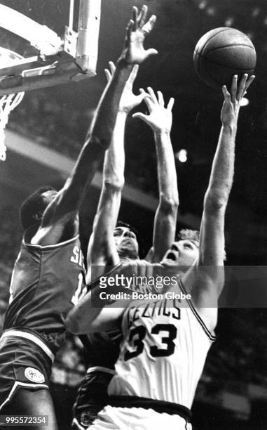 Boston Celtics' Larry Bird scores over Philadelphia's Maurice Cheeks and Bobby Jones during the third quarter of Game Two of the second round of the...