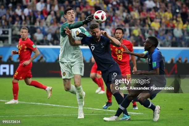 Thibaut Courtois of Belgium clears the ball under pressure from Olivier Giroud of France during the 2018 FIFA World Cup Russia Semi Final match...