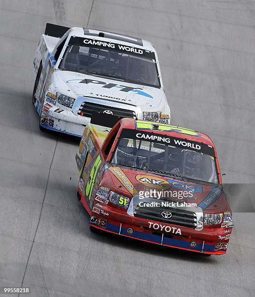 Aric Almirola, driver of the Graceway Pharm/AKawareness.com Toyota, leads Justin Lofton, driver of the visitpit.com Toyota during the NASCAR Camping...
