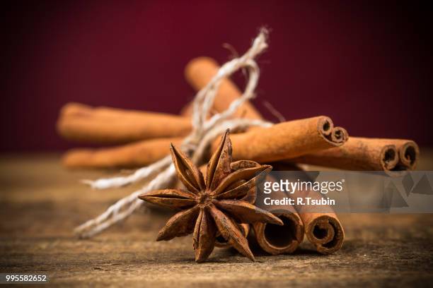 close up of cinnamon sticks and star anise on rustic wood background - rustic star stock-fotos und bilder
