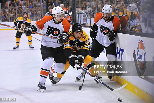 Marc Savard of the Boston Bruins skates after the puck against Danny Briere and Ville Leino of the Philadelphia Flyers in Game Seven of the Eastern...