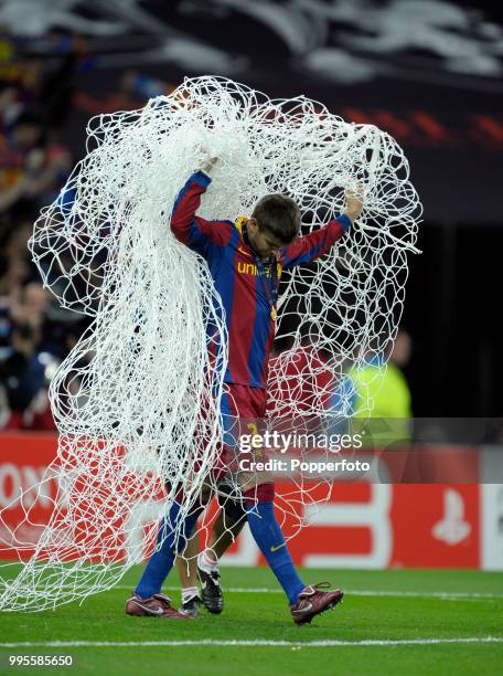 Gerard Pique of FC Barcelona takes home a souvenir, the net in which the winning goals were scored, following the UEFA Champions League final between...
