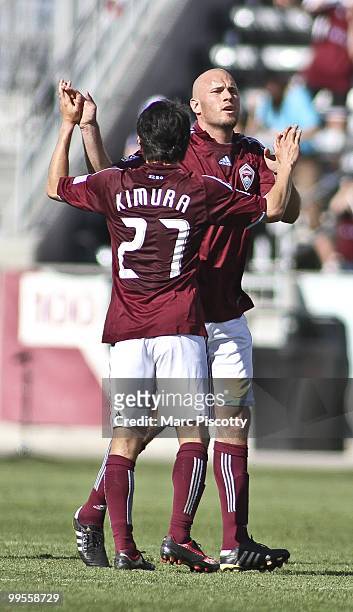 Conor Casey of the Colorado Rapids gets a high five from teammate Kosuke Kimura after scoring his second penalty kick goal of the game against...