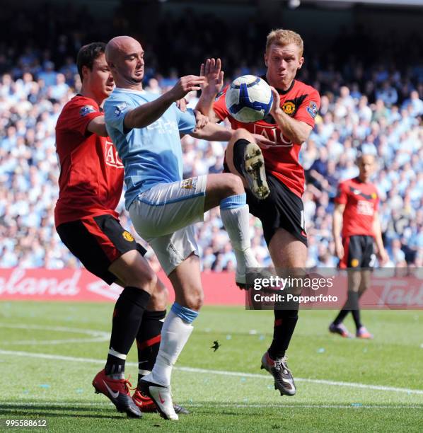 Stephen Ireland of Manchester City is challenged by Jonny Evans and Paul Scholes of Mancheseter United during the Barclays Premier League match...