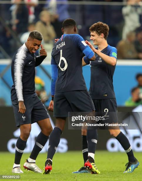 Benjamin Pavard, Paul Pogba and Presnel Kimpembe of France celebrate victory following the 2018 FIFA World Cup Russia Semi Final match between...