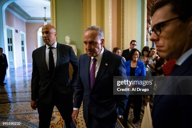 Senate Minority Leader Chuck Schumer departs with Sen. Cory Booker , left, and Matt House, Schumer's communications director, right, following a news...
