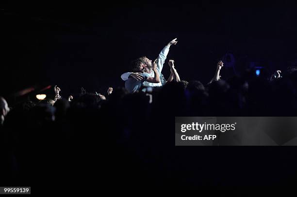 The fans of Argentine singer Andres Calamaro embrace as he performs in Montevideo on May 14, 2010. AFP PHOTO/Pablo PORCIUNCULA