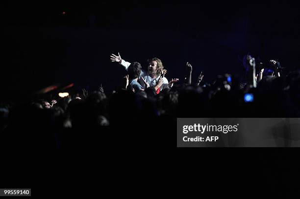 The fans of Argentine singer Andres Calamaro embrace as he performs in Montevideo on May 14, 2010. AFP PHOTO/Pablo PORCIUNCULA