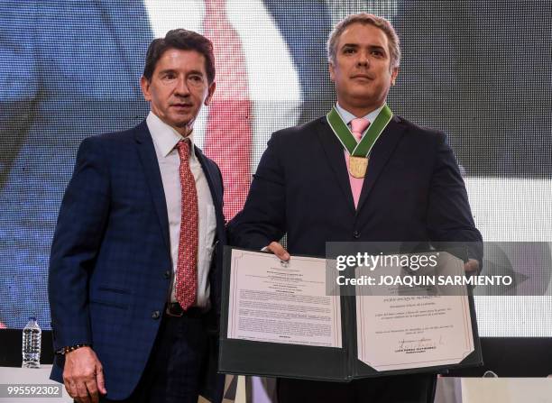 Colombian President-elect Ivan Duque poses next to Antioquia's Governor Luis Perez after he was decorated with the "Escudo de Antioquia" during the...