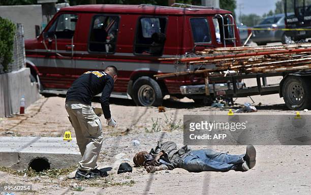Police officer places markers next to one of six corpses that were found in Ciudad Juarez, Mexico on May 14, 2010. Ciudad Juarez, with 1.3 million...