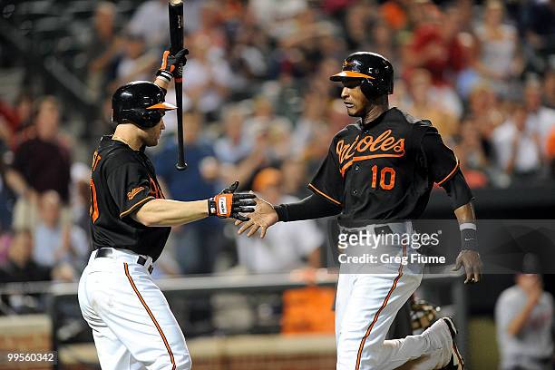 Adam Jones of the Baltimore Orioles celebrates with Luke Scott after scoring in the seventh inning against the Cleveland Indians at Camden Yards on...
