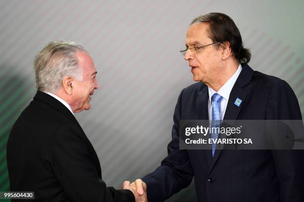 Brazilian President Michel Temer shakes hands with his new Labour Minister Caio Vieira de Mello during his inauguration ceremony at the Planalto...