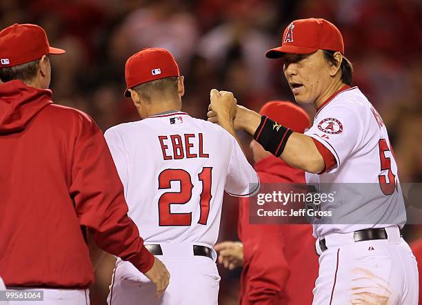Hideki Matsui of the Los Angeles Angels of Anaheim receives a high five from third base coach Dino Ebel following the game against the Oakland...