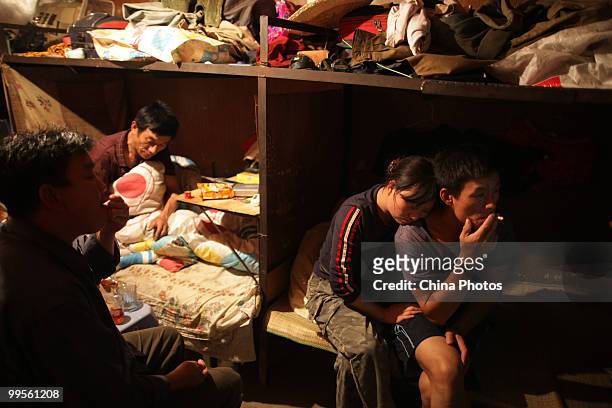 Migrant workers 35-year-old Jiang Zhirong rests on the shoulder of her 35-year-old husband Gong Junan , in a shipping container house at the south...