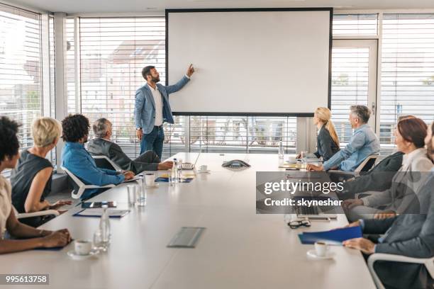 ceo geven van een bedrijfspresentatie via projectiescherm in een bestuurskamer. - projection screen stockfoto's en -beelden