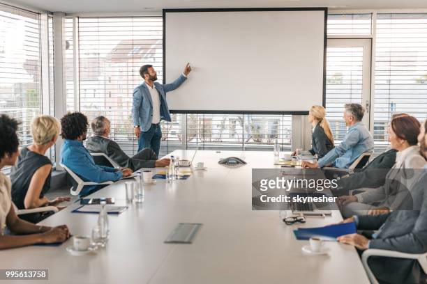 ceo giving a business presentation through projection screen in a board room. - business strategy whiteboard stock pictures, royalty-free photos & images