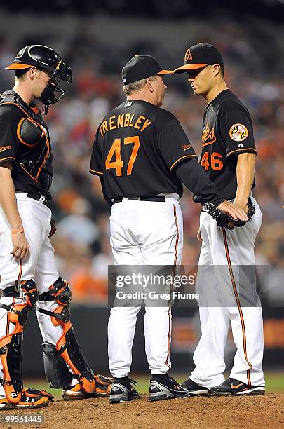 Jeremy Guthrie of the Baltimore Orioles talks with manager Dave Trembley and Matt Wieters during the game against the Cleveland Indians at Camden...