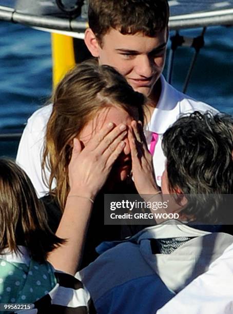 Australian round-the-world sailor, Jessica Watson , age 16, wipes away tears as she steps ashore and meets her mother Julie , after bringing her...