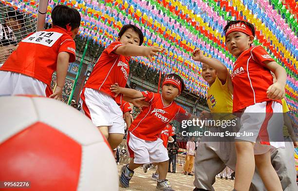 Young four and five-year-old children play a friendly game of soccer underneath colorful hanging paper lanterns at the Chogye Temple on May 15, 2010...