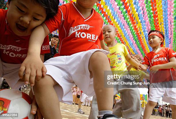 Young four and five-year-old children play a friendly game of soccer underneath colorful hanging paper lanterns at the Chogye Temple on May 15, 2010...