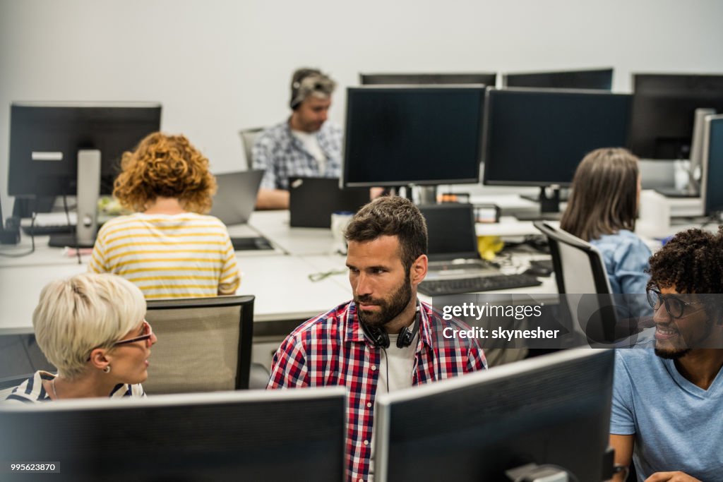 Young Computer Programmers Talking While Working In The Office High-Res ...