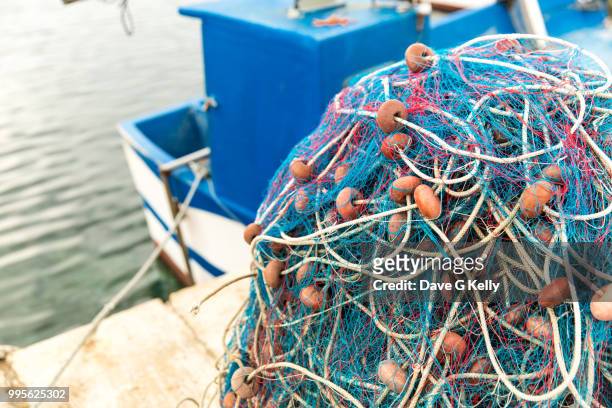 trawler net in a mound on a pier - trawler net stock pictures, royalty-free photos & images
