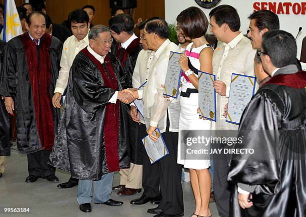 Commission on Elections Chairman Jose Melo shakes hands with the newly elected Philippine senators elected senators Ramon 'Bong' Revilla Jnr, Jose...