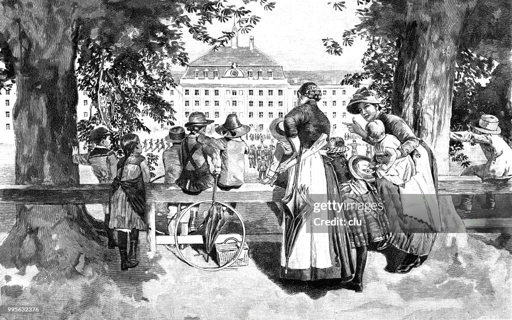 Women and children watching the soldiers in the barracks
