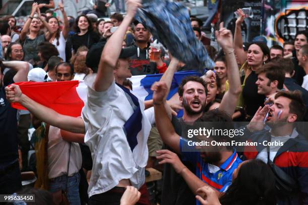 French fans erupt with joy, outside a local bar in the 20th arrondissement, as France wins its semi-final World Cup match against Belgium, on July...