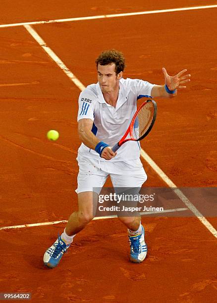 Andy Murray of Great Britain slides to play a backhand to David Ferrer of Spain in their quarter final match during the Mutua Madrilena Madrid Open...