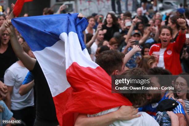 French fans erupt with joy, outside a local bar in the 20th arrondissement, as France wins its semi-final World Cup match against Belgium, on July...