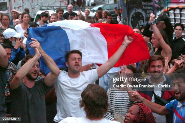 French fans erupt with joy, outside a local bar in the 20th arrondissement, as France wins its semi-final World Cup match against Belgium, on July...