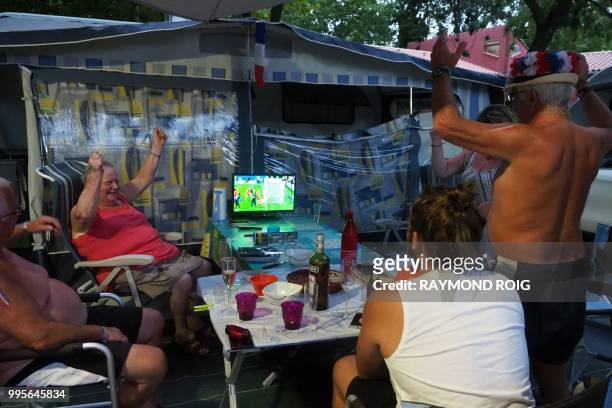 French holidaymakers look at a television set at a camp site in Argeles-sur-Mer on July 10 as they watch the 2018 Russia World Cup semi-final...