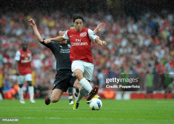 Samir Nasri of Arsenal is tackled from behind by Charlie Adam of Liverpool during the Barclays Premier League match between Arsenal and Liverpool at...