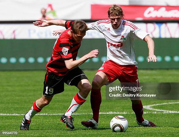 Dmitri Tarasov of FC Lokomotiv Moscow battles for the ball with Aleksandr Kolomeytsev of FC Amkar Perm during the Russian Football League...