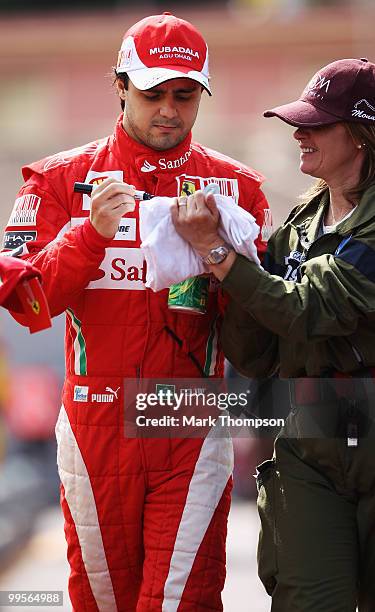 Felipe Massa of Brazil and Ferrari signs autographs before driving in the final practice session prior to qualifying for the Monaco Formula One Grand...