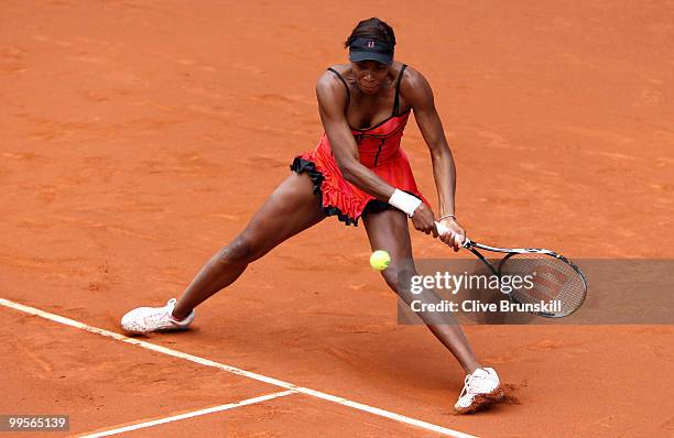 Venus Williams of the USA plays a backhand against Shahar Peer of Israel in their semi final match during the Mutua Madrilena Madrid Open tennis...