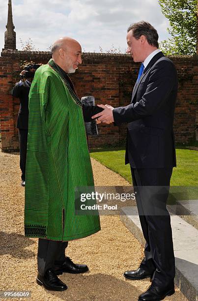 Prime Minister David Cameron shakes hands with Aghan President Hamid Karzai, at Chequers, on May 15, 2010 in Ellesborough, England. The talks,...