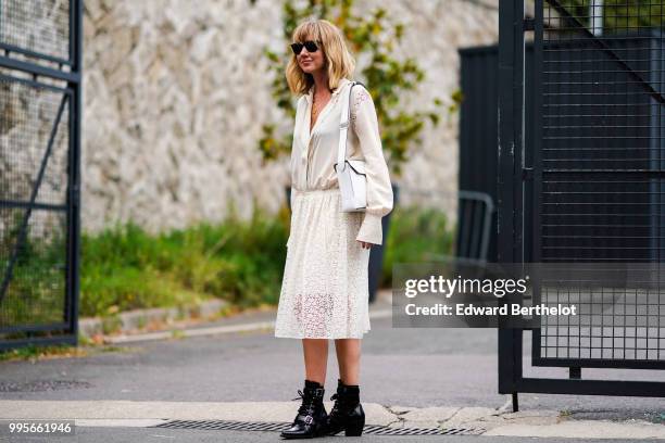 Lisa Aiken wears a white lace dress, a white bag, black shoes , outside Vetements, during Paris Fashion Week Haute Couture Fall Winter 2018/2019, on...