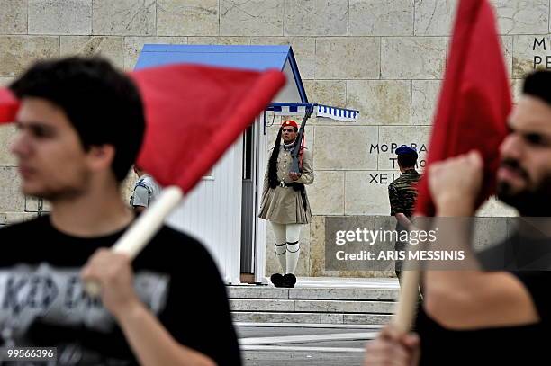 Communist demonstrators of the KKE stand in front of a Greek presidential guard outside the parliament on May 15, 2010 to protest against the...