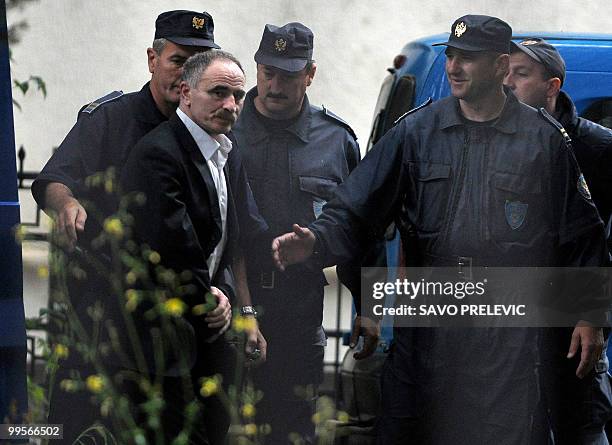 Mladjen Govedarica , an ex-soldier of the former Yugoslav army, is escorted by Montenegrin police officers into a court in Podgorica on May 15, 2010....