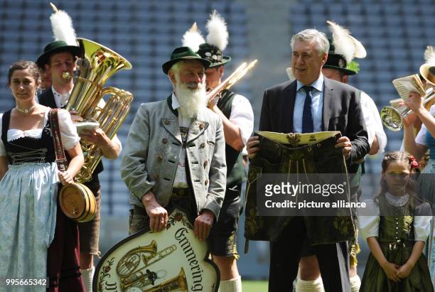 New head coach Carlo Ancelotti of German Bundesliga team FC Bayern Munich can be seen next to a brass band holding a pair of traditional leather...