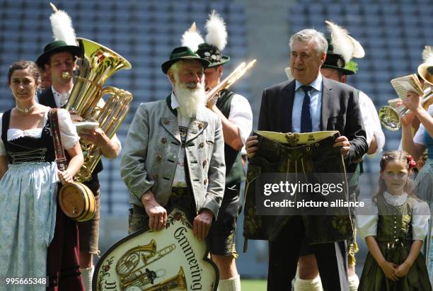 New head coach Carlo Ancelotti of German Bundesliga team FC Bayern Munich can be seen next to a brass band holding a pair of traditional leather...