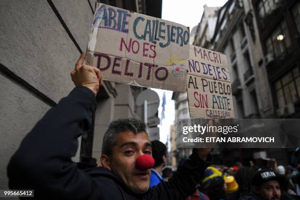 Street artist takes part in a demonstration in front of the Buenos Aires City Legislature in the Argentine capital on July 10 rejecting a bill that...