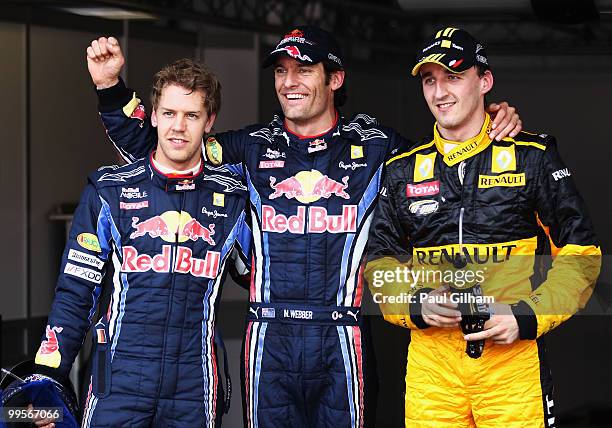 First placed Mark Webber of Australia and Red Bull Racing celebrates in parc ferme with second placed Robert Kubica of Poland and Renault and third...