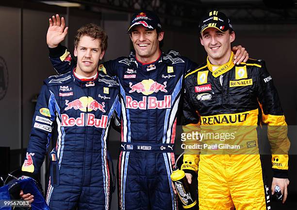 First placed Mark Webber of Australia and Red Bull Racing celebrates in parc ferme with second placed Robert Kubica of Poland and Renault and third...